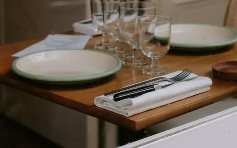 Restaurant table set with plates, glasses and cutlery.